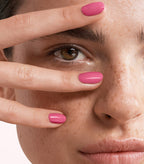 Close-up of a woman with Pink Gellac 220 Pretty Pink manicured nails near her face.
