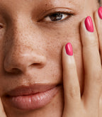 Close-up of a woman with Pink Gellac 222 Amazing Pink manicured nails near her face.