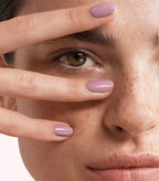 Close-up of a woman with Pink Gellac 224 Soft Purple manicured nails near her face.