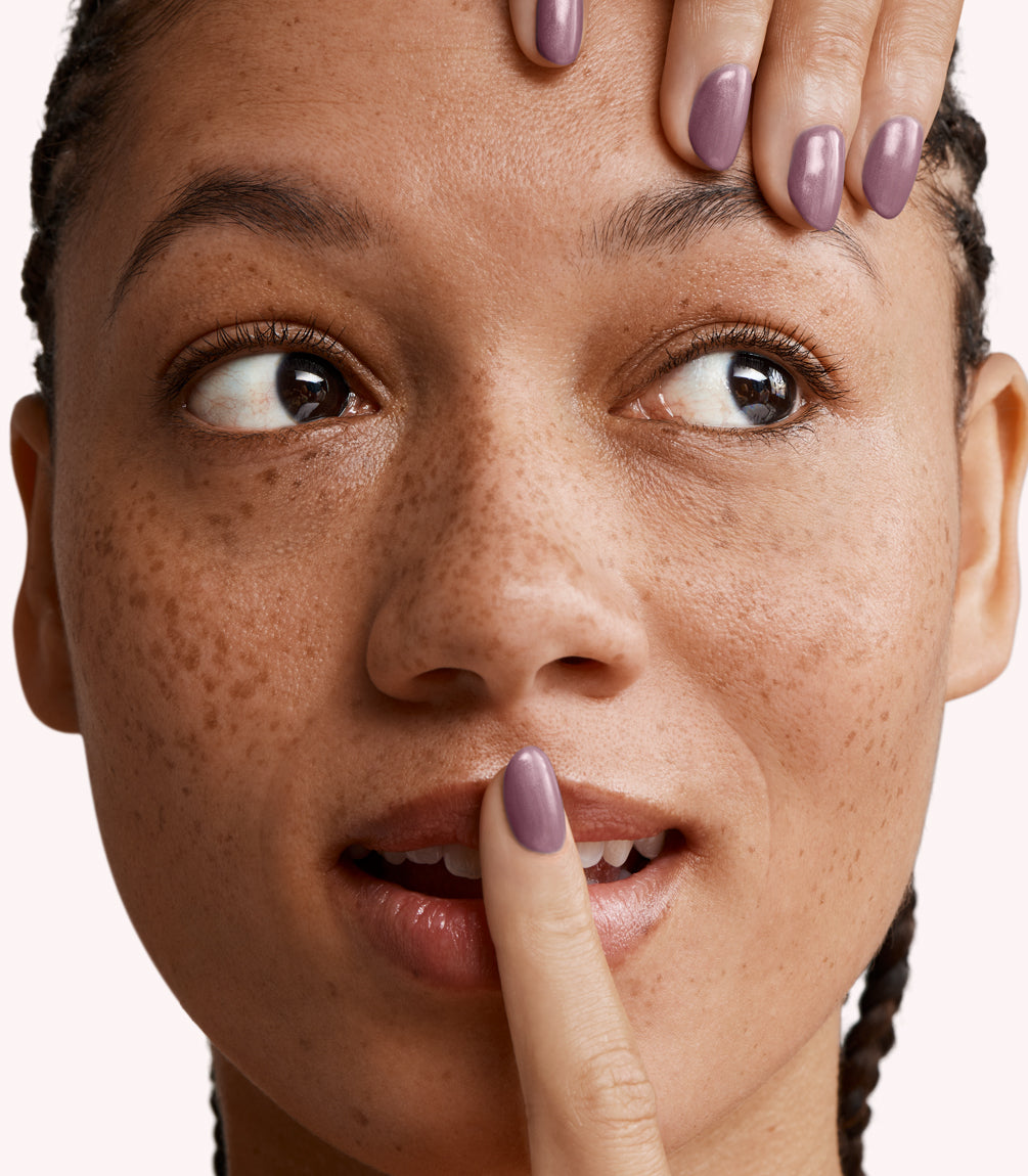 Close-up of a woman with Pink Gellac 225 Shimmery Mauve manicured nails near her face.