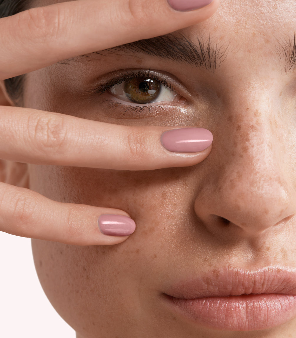 Close-up of a woman with Pink Gellac 226 Neutral Lila manicured nails near her face.