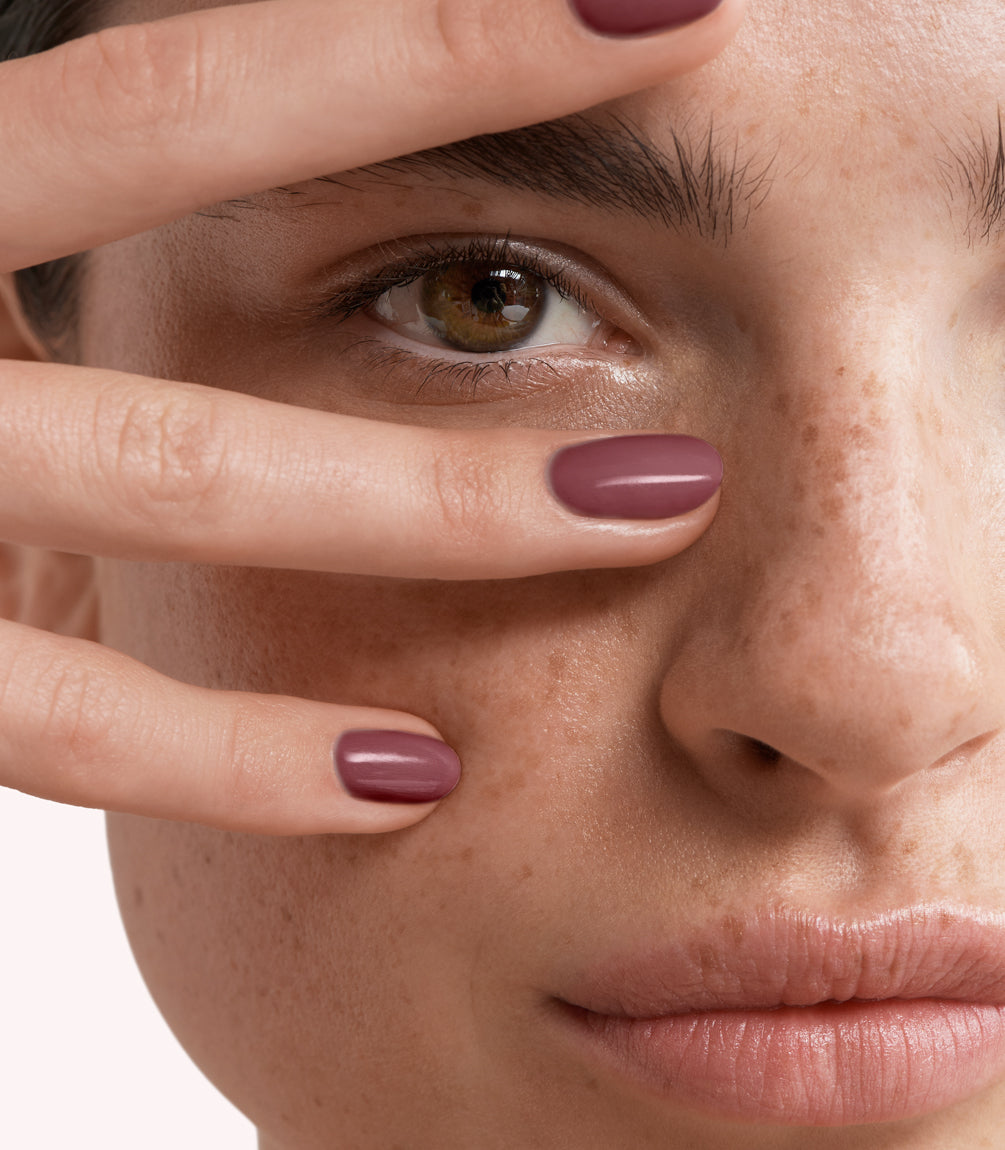 Close-up of a woman with Pink Gellac 228 Creamy Mauve manicured nails near her face.
