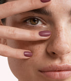 Close-up of a woman with Pink Gellac 228 Creamy Mauve manicured nails near her face.