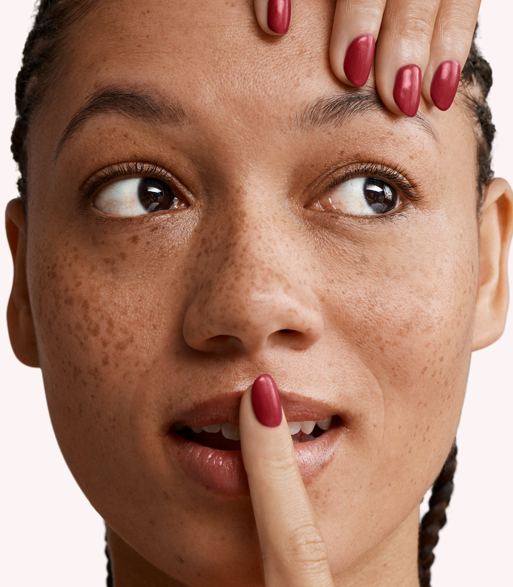 Close-up of a woman with Pink Gellac 230 Amorous Red manicured nails near her face.