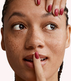 Close-up of a woman with Pink Gellac 230 Amorous Red manicured nails near her face.