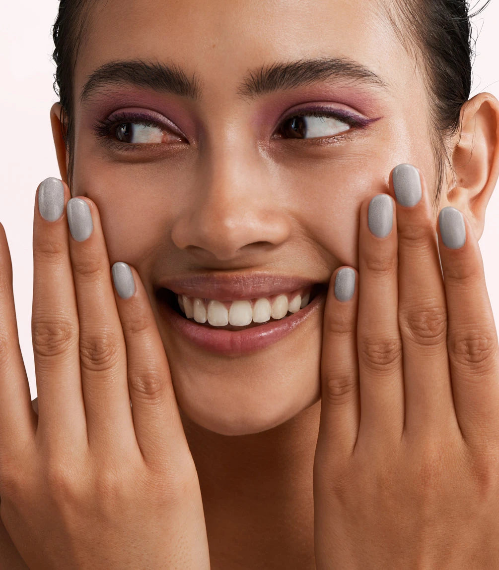 Close-up of a woman with Pink Gellac 231 Strictly Silver manicured nails near her face.