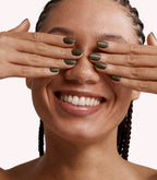 Close-up of a woman with Pink Gellac 234 Metalized Bronze manicured nails near her face.