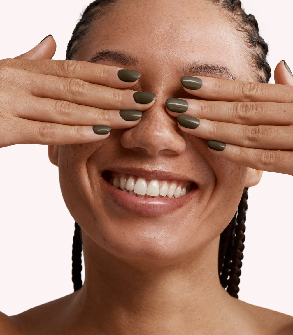 Close-up of a woman with Pink Gellac 234 Metalized Bronze manicured nails near her face.