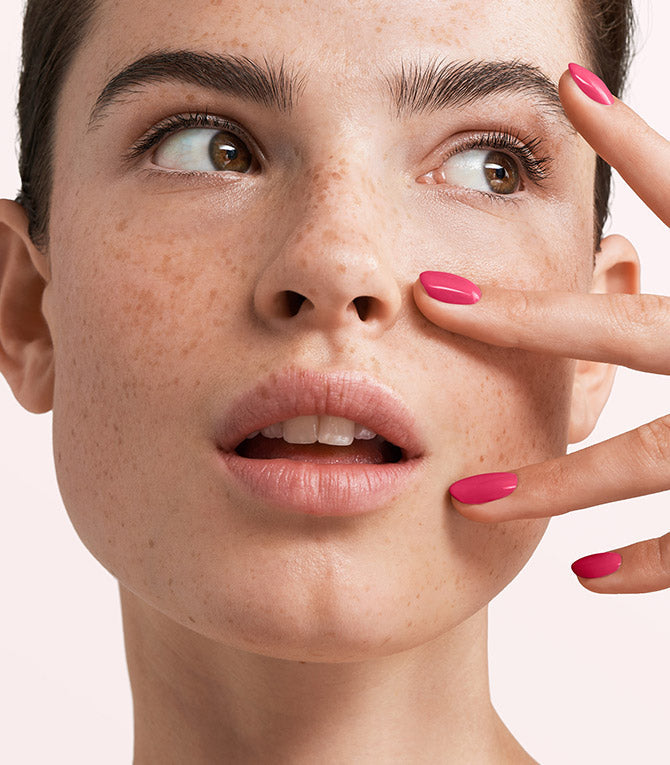 Close-up of a woman with Pink Gellac 247 Sorbet Pink manicured nails near her face.