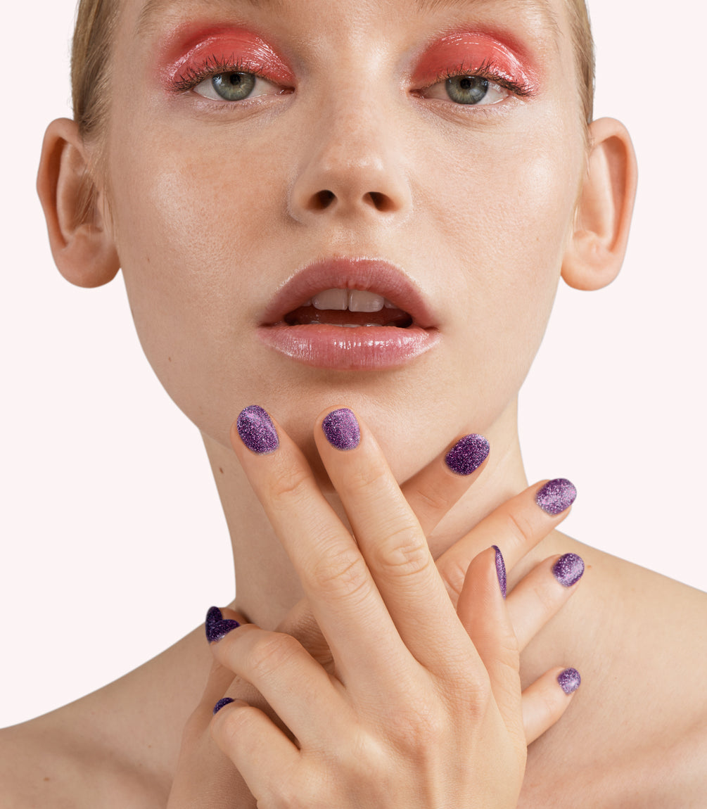 Close-up of a woman with Pink Gellac 248 Midnight Purple manicured nails near her face.