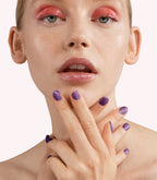 Close-up of a woman with Pink Gellac 248 Midnight Purple manicured nails near her face.