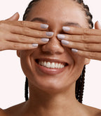 Close-up of a woman with Pink Gellac 255 Frosted Nude manicured nails near her face.
