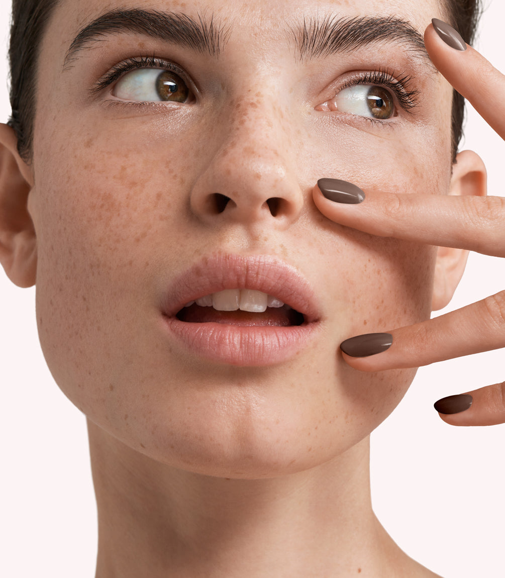 Close-up of a woman with Pink Gellac 259 Hazelnut Brown manicured nails near her face.