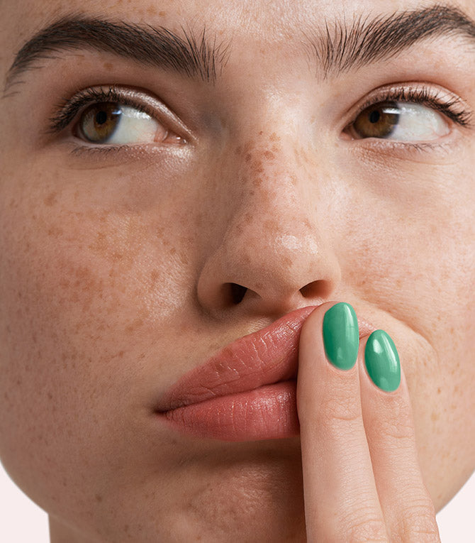 Close-up of a woman with Pink Gellac 271 Palmbeach Green manicured nails near her face.