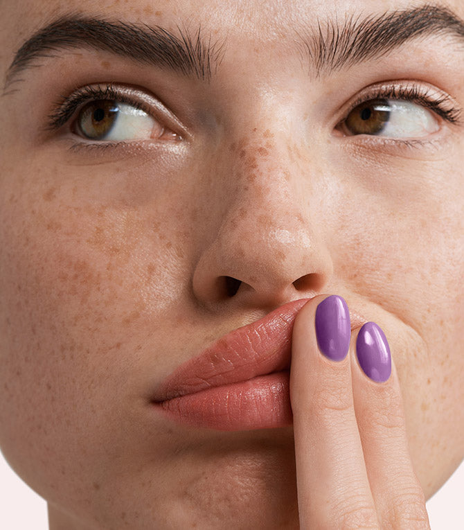 Close-up of a woman with Pink Gellac 273 Key Largo Purple manicured nails near her face.
