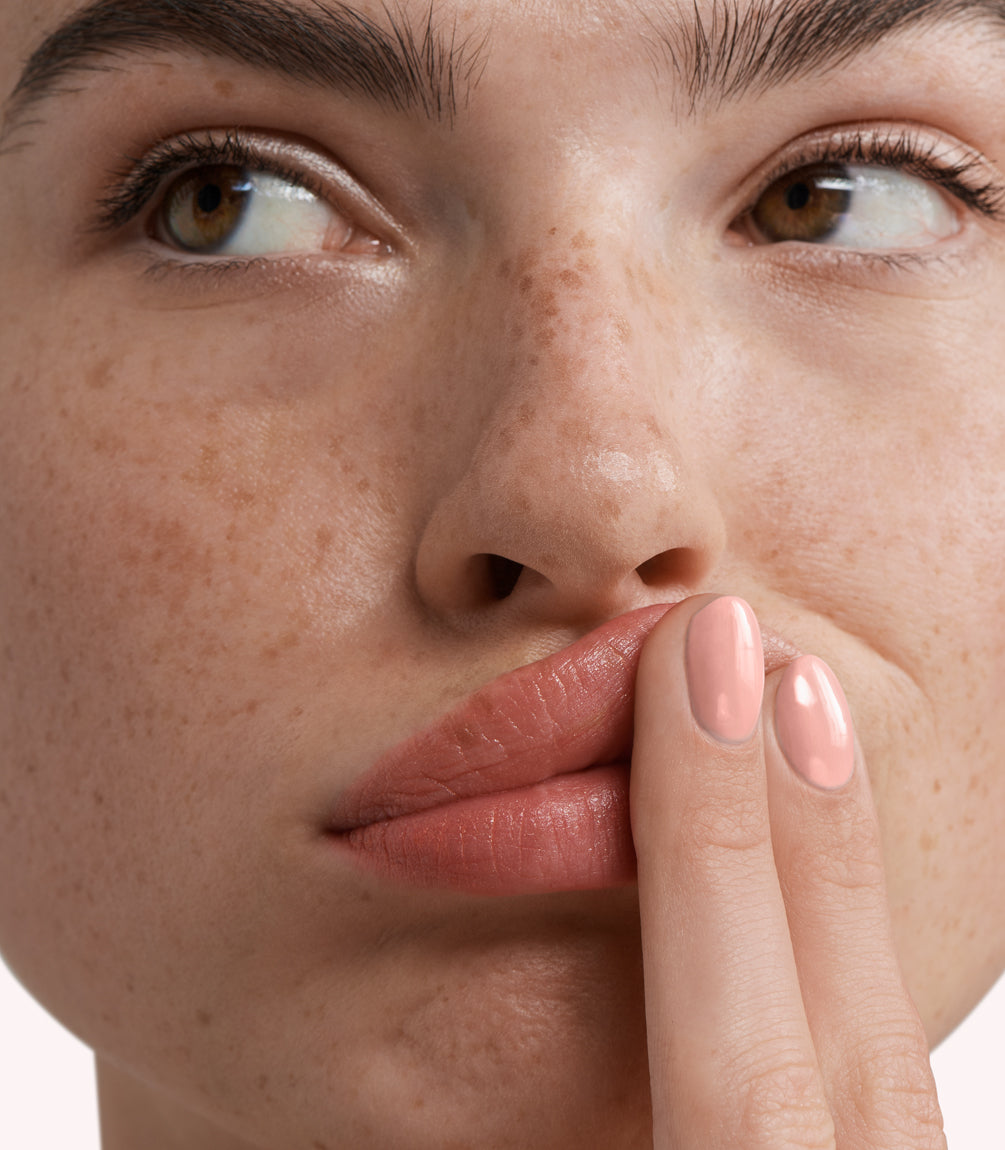 Close-up of a woman with Pink Gellac 274 Pale Pink manicured nails near her face.