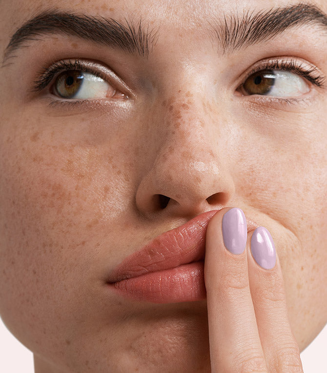 Close-up of a woman with Pink Gellac 277 Neutral Lavender manicured nails near her face.
