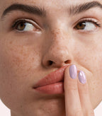 Close-up of a woman with Pink Gellac 277 Neutral Lavender manicured nails near her face.