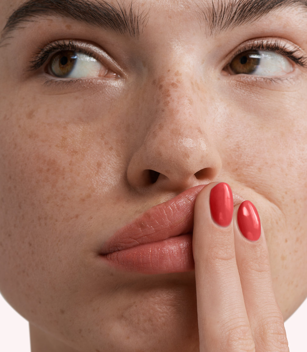 Close-up of a woman with Pink Gellac 281 Regal Red manicured nails near her face.