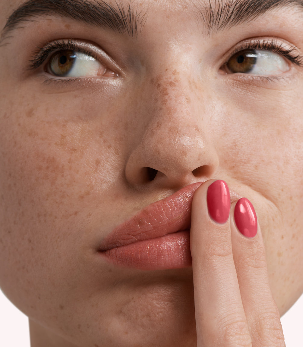 Close-up of a woman with Pink Gellac 282 Dusky Pink manicured nails near her face.