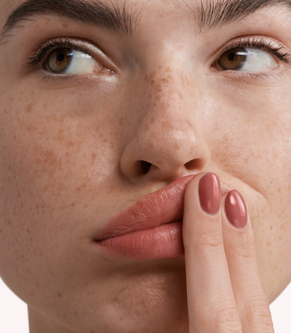 Close-up of a woman with Pink Gellac 283 Rosy Brown manicured nails near her face.