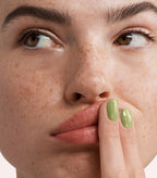 Close-up of a woman with Pink Gellac 284 Spring Green manicured nails near her face.