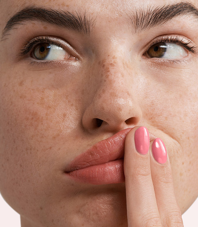 Close-up of a woman with Pink Gellac 285 Happy Pink manicured nails near her face.