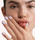 Close-up of a woman with Pink Gellac 297 Lavender Grey manicured nails near her face.