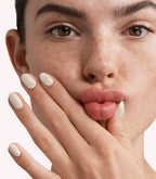 Close-up of a woman with Pink Gellac 298 Porcelain Beige manicured nails near her face.