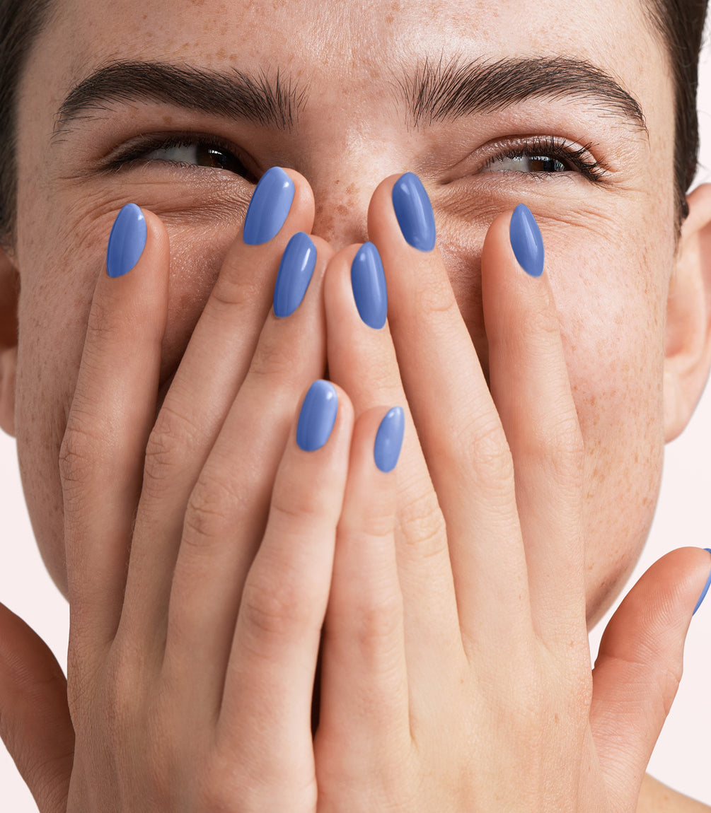 Close-up of a woman with Pink Gellac 301 Azure Blue manicured nails near her face.