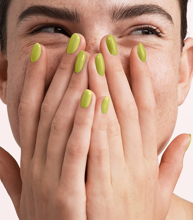 Close-up of a woman with Pink Gellac 302 Lime Green manicured nails near her face.