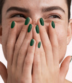 Close-up of a woman with Pink Gellac 309 Graceful Green manicured nails near her face.