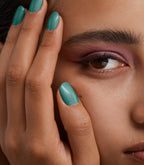 Close-up of a woman with Pink Gellac 310 Tempting Teal manicured nails near her face.
