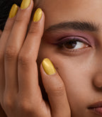 Close-up of a woman with Pink Gellac 311 Crushed Gold manicured nails near her face.