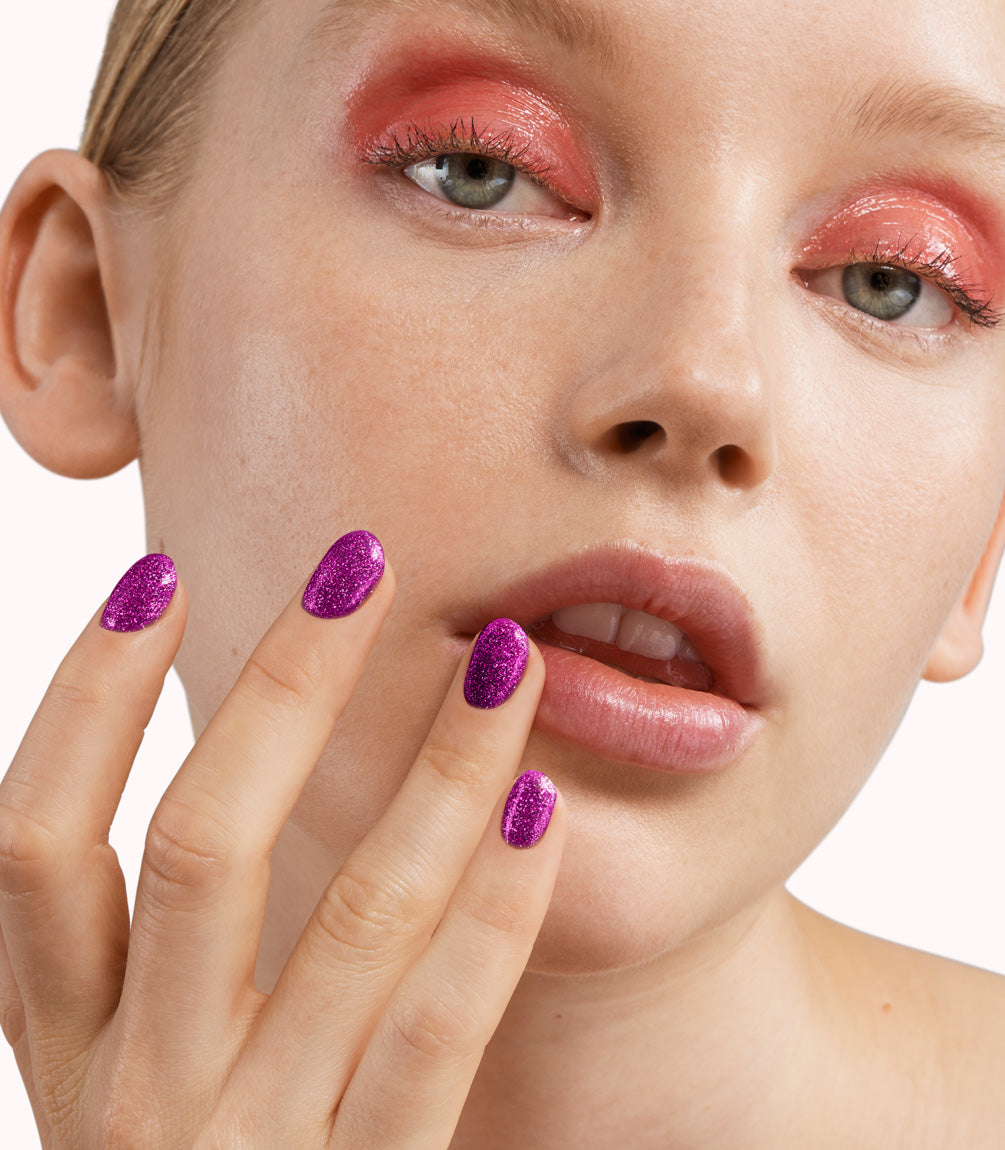 Close-up of a woman with Pink Gellac 312 Fabulous Fuchsia manicured nails near her face.