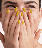 Close-up of a woman with Pink Gellac 314 Lion Yellow manicured nails near her face.