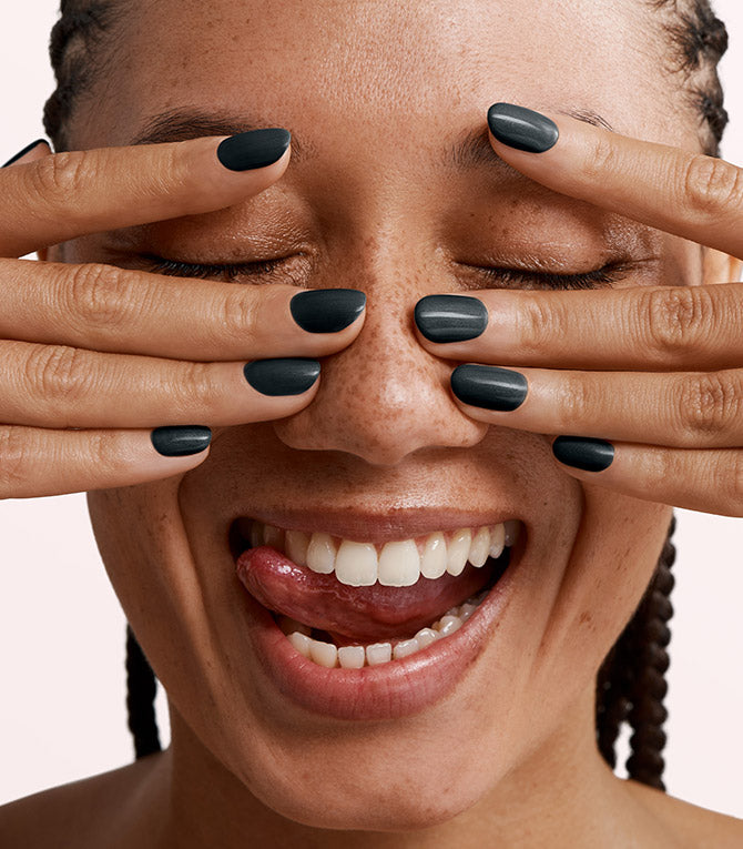 Close-up of a woman with Pink Gellac 317 Star Sky Black manicured nails near her face.
