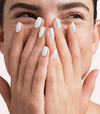 Close-up of a woman with Pink Gellac 319 Decent White manicured nails near her face.