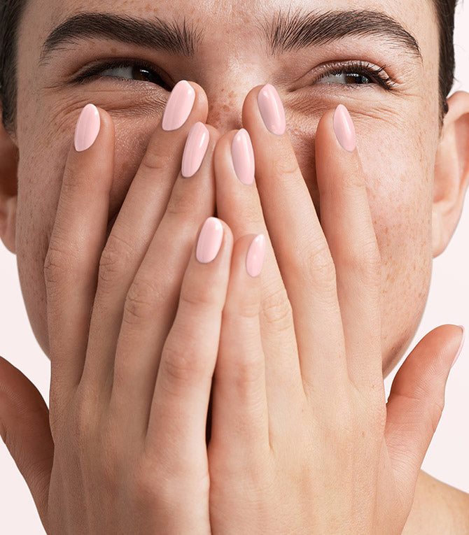Close-up of a woman with Pink Gellac 320 Powder Pink manicured nails near her face.