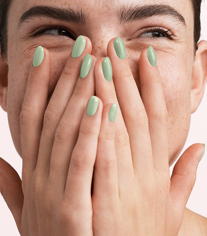 Close-up of a woman with Pink Gellac 323 Gentle Jade manicured nails near her face.