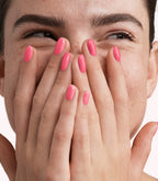 Close-up of a woman with Pink Gellac 325 Taffy Pink manicured nails near her face.