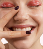 Close-up of a woman with Pink Gellac 333 Oriental Spice manicured nails near her face.