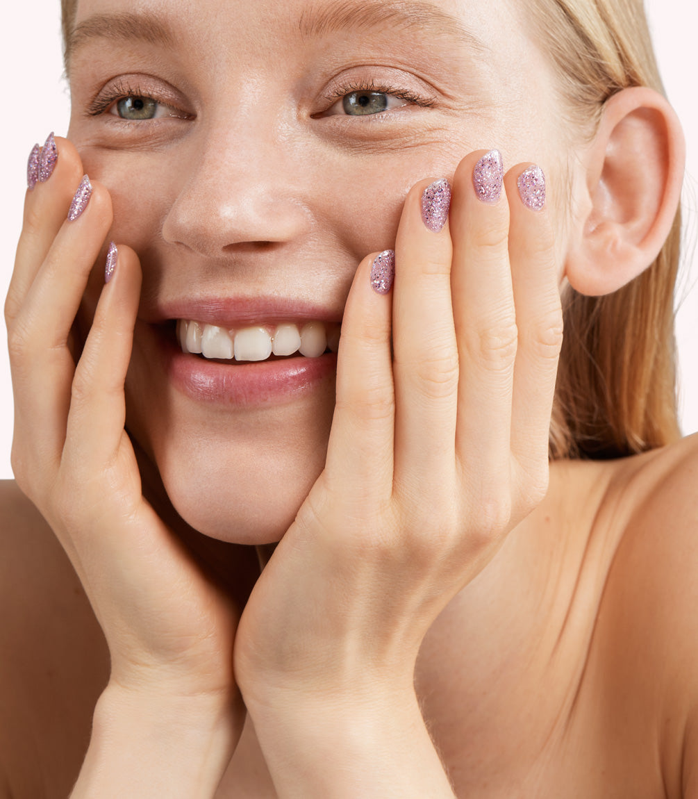 Close-up of a woman with Pink Gellac 336 Starlight Plum manicured nails near her face.