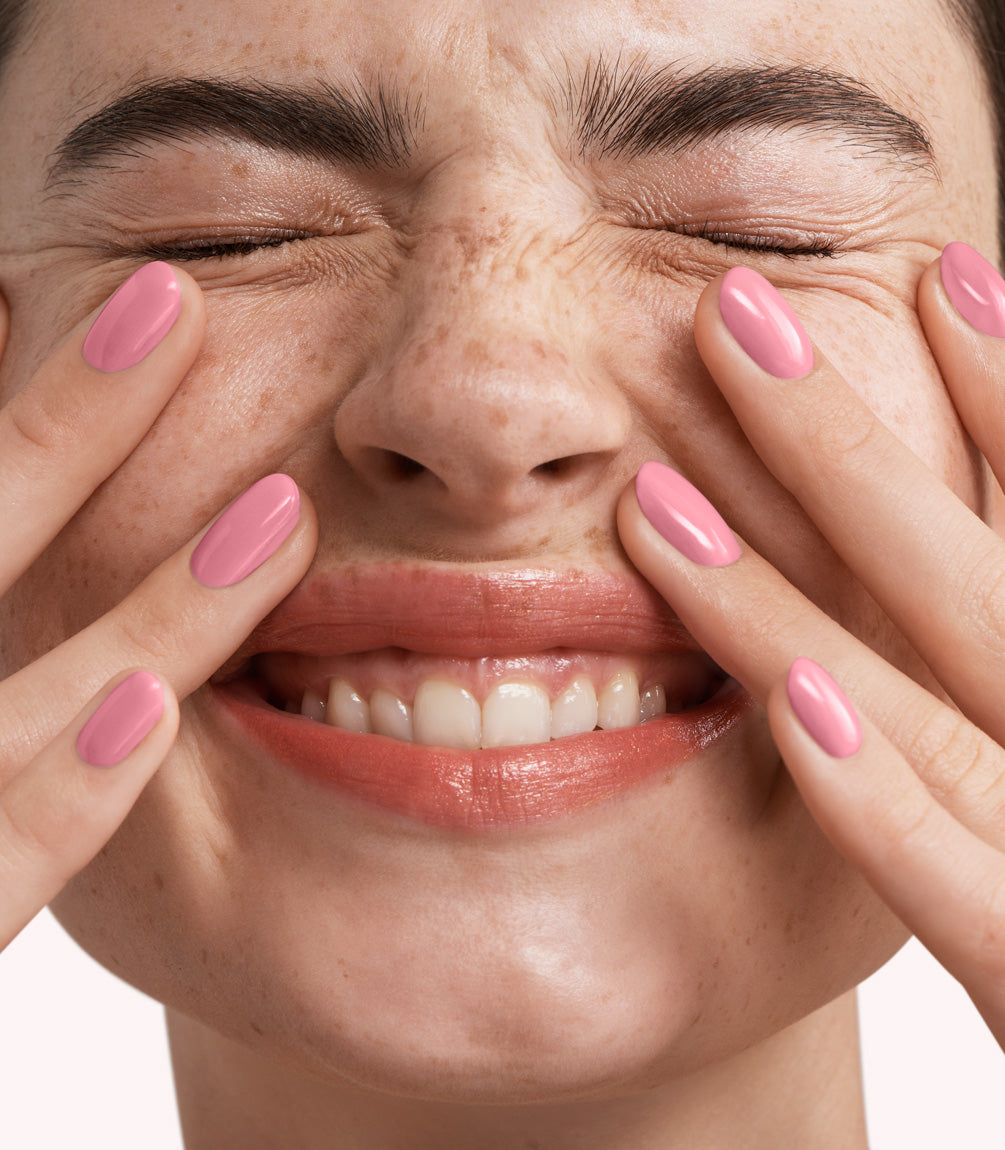 Close-up of a woman with Pink Gellac 340 Sweet Pink manicured nails near her face.