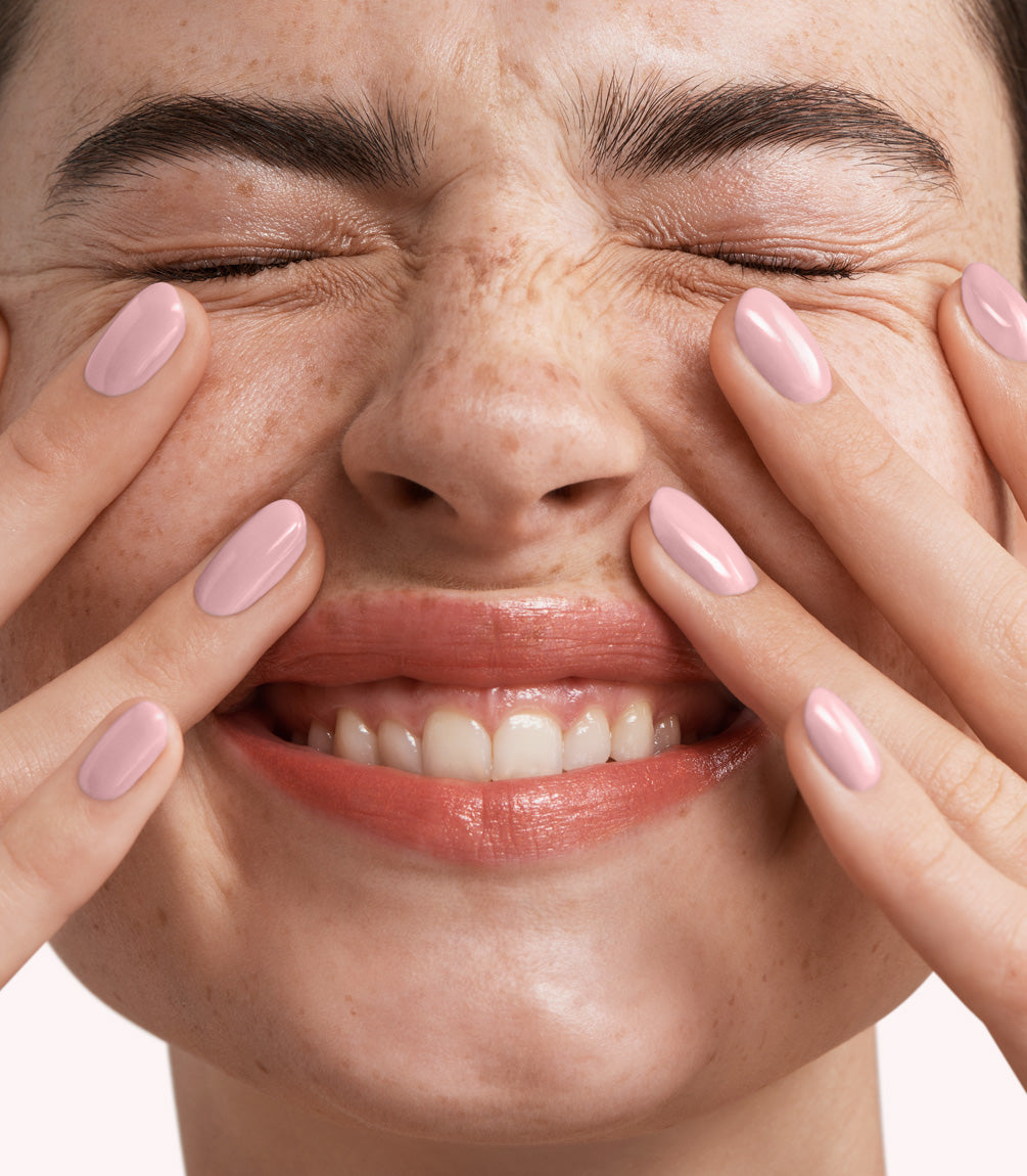 Close-up of a woman with Pink Gellac 345 Heavenly Pink manicured nails near her face.
