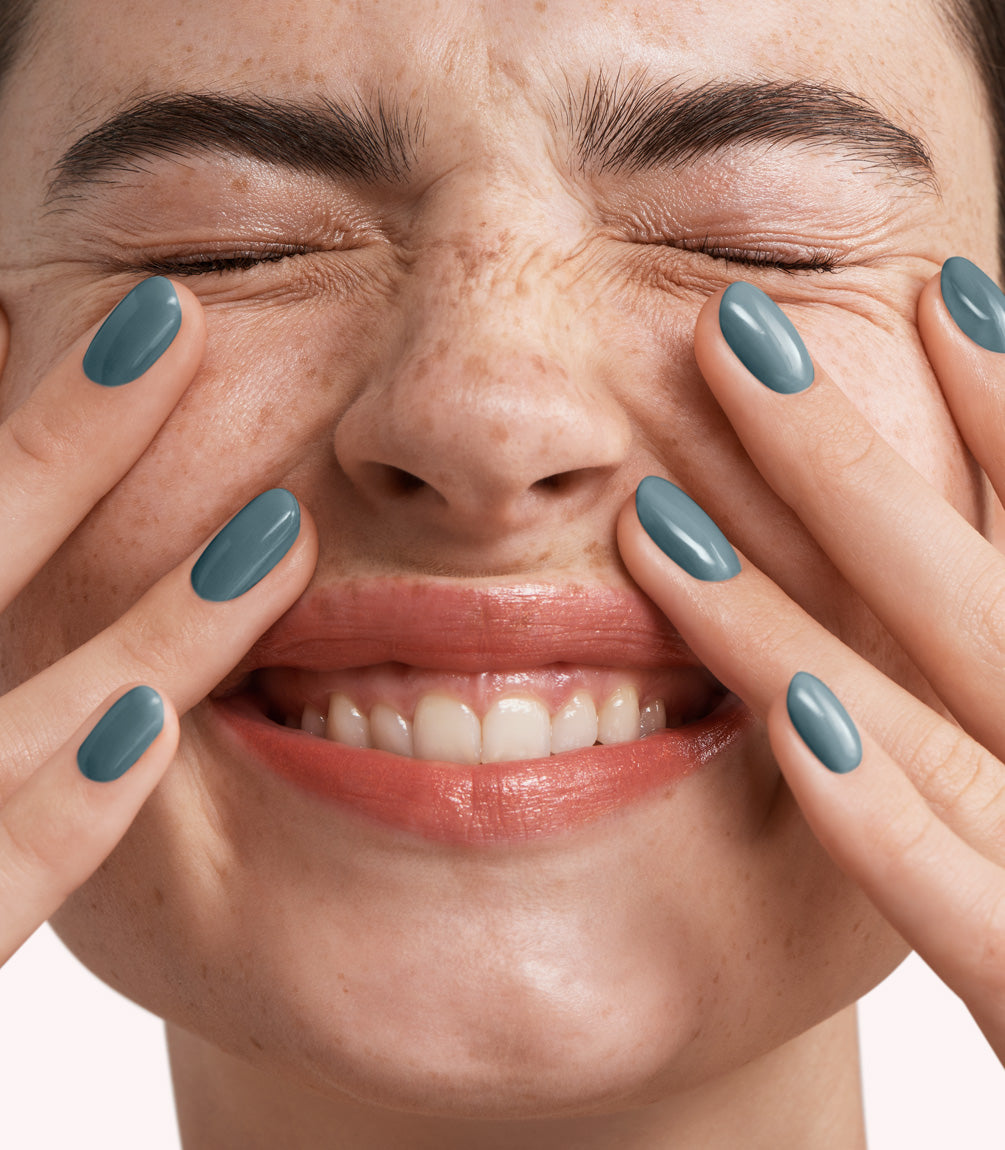 Close-up of a woman with Pink Gellac 348 Teal Blue manicured nails near her face.