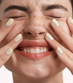 Close-up of a woman with Pink Gellac 351 Confetti Cream manicured nails near her face.