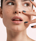 Close-up of a woman with Pink Gellac 358 Dove Grey manicured nails near her face.