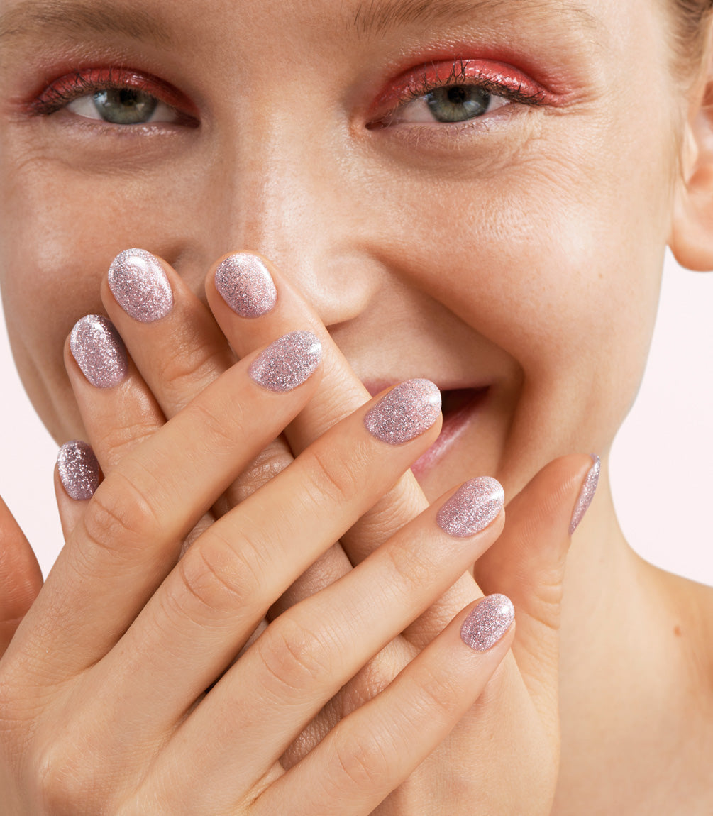 Close-up of a woman with Pink Gellac 359 Twinkling Lilac manicured nails near her face.