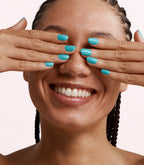 Close-up of a woman with Pink Gellac 372 Laguna Blue manicured nails near her face.